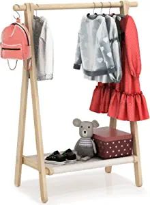 a wooden coat rack with clothes and a stuffed animal on the shelf next to it