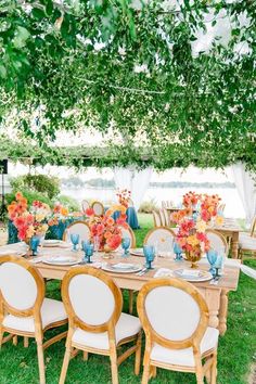 an outdoor table set up with blue and orange flowers