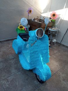 a scooter made out of blue paper and some flowers