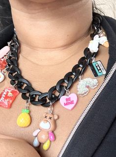 "🌈Introducing our chic matte black acrylic chain necklace with a delightful assortment of 11 charms that effortlessly blend resin, plastic, and metal elements.  🧸This statement piece boasts a unique combination of charms, including an adorable ice cream cone, whimsical unicorn, vintage tape with the message \"good vibes,\" tropical pineapple, and a vibrant 1.5-inch resin teddy bear.  🍍Each charm is thoughtfully chosen to create a playful yet sophisticated look. Elevate your style with this ve Handmade Black Plastic Jewelry, Trendy Party Charm Necklaces, Trendy Charm Necklaces For Party, Trendy Black Charms Jewelry, Trendy Black Jewelry With Charms, Cute Black Jewelry With Charms, Trendy Black Charm Necklace For Party, Cute Black Resin Jewelry, Trendy Black Charm Necklace With Chain