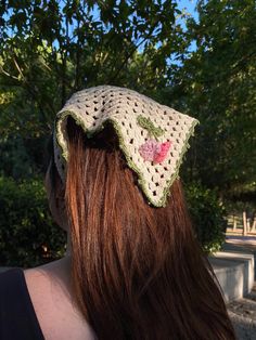 a woman with long hair wearing a crocheted hat on top of her head