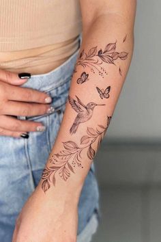 a woman's arm with a tattoo on it and flowers in the middle of her arm