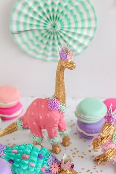 a table topped with cupcakes covered in frosting and decorated like an animal