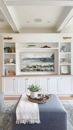 a living room filled with furniture and a painting on the wall above it's mantle