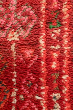 a close up view of a red rug with flowers on it