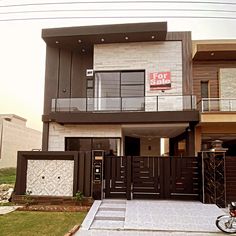 a house with a for sale sign in front of it and a bicycle parked outside