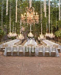 an outdoor wedding with chandeliers and tables