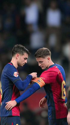 two soccer players standing next to each other