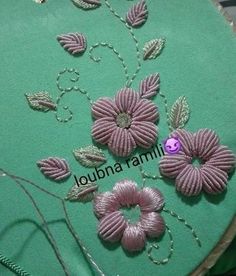 a close up of a piece of cloth with flowers on it and thread in the middle