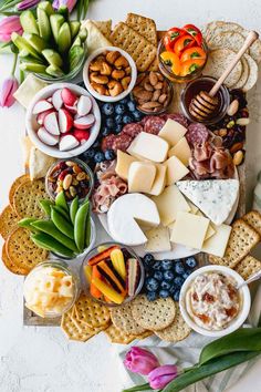 a platter filled with cheese, crackers and other food on top of a table