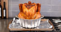 a roasting pan with a whole chicken in it on top of a stovetop