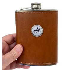 a hand holding a flask with a horse on it