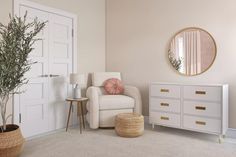 a living room with white furniture and a round mirror on the wall