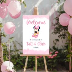 a welcome sign for a baby girl with minnie mouse on it and balloons in the background