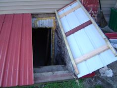 an open door in the side of a house that has been gutted with tin