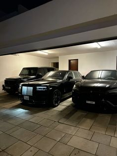 three black cars parked in a garage next to each other