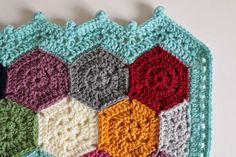 a crocheted square with different colors and shapes on the top, in varying sizes