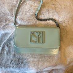 -Mint Shoulder Bag With “Sm” Logo Charm On The Front. -Has Chain Link/Faux Leather Shoulder Bag. -Inside Has One Zippered Pocket With Two Sleeve Pockets. -Bag Can Be Worn As A Shoulder Bag Or As A Clutch. -Has Magnetic Strap Closure. -New With Tags. No Damages. Dimensions: W: 9 3/4” H: 6” D: 2 1/4” Elegant Tan Shoulder Bag For Spring, Chic Tan Shoulder Bag For Spring, Chic Tan Shoulder Bag With Chain Strap, Chic Tan Clutch Shoulder Bag, Chic Tan Bag With Chain Strap, Sm Logo, Mint Shorts, Steve Madden Bags, Bag Inside