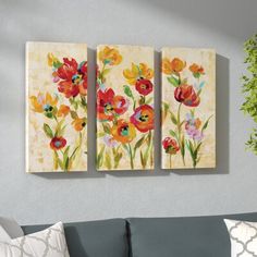 three paintings hanging on the wall above a couch