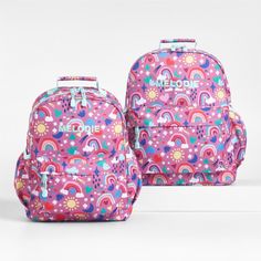 A backpack that's extra comfy and ready to handle daily adventures. A whimsical mix of raindrops, rainbows, stars and more shower the magenta exterior of our kids' large knapsack, and light aqua trim adds an extra burst of color. It's constructed of supremely durable polyester made from recycled water bottles and has a roomy interior to hold everything your kid needs—books, school supplies, extra layers. There's even a padded pocket to keep their tablet protected. Outside pockets hold snacks, wa Rainbow Standard Backpack For Back To School, Playful Rainbow School Bag, Rainbow-colored Standard Backpack For School, Rainbow School Backpack, Rainbow Colored School Backpack, Rainbow Standard School Backpack, Playful Pink Backpack For Outdoor Activities, Playful Purple Backpack, Kids School Backpack