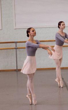 two young ballerinas are practicing their moves