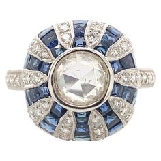 Art Deco inspired ring with a rose cut diamond and French cut sapphires. 1.18ct center rose cut diamond. Complimented with 0.40ct of round diamonds and 0.80ct of French cut sapphires heat. 2.38ct total gemstone weight. 18k white gold with milgrain and filigree work. Accommodated with an up to date appraisal by a GIA G.G. upon request. Please contact us with any questions. Item Number R8858 1 Rose Cut Diamond = 1.18ct, approximately J/K color and SI clarity 36 Round Diamonds = 0.40ct, approximate Modern Diamond Jewelry, Diamond Sapphire Ring, Hand Rings, Edwardian Jewelry, Gold For Sale, Round Sapphire, French Cut, 1 Rose, Sapphire Diamond Ring