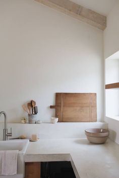 a kitchen with a sink, counter top and wooden utensils on the wall