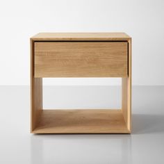 a small wooden table with one drawer on the top and two shelves below it, against a white background