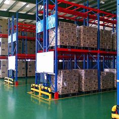 a large warehouse filled with lots of pallets and boxes on top of metal racks