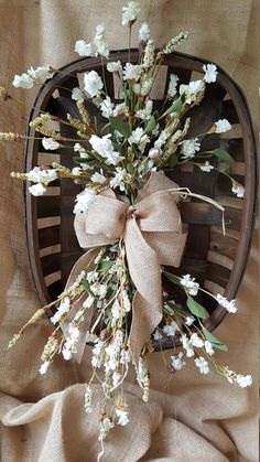 a bunch of flowers that are sitting in a basket on a table with burlocks