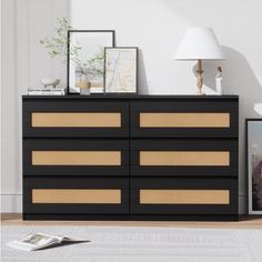 a black and gold dresser in a white room with pictures on the wall next to it