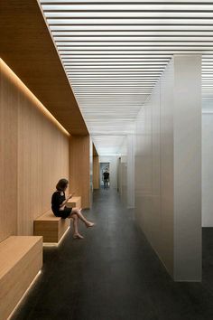 a person sitting on a bench in a hallway