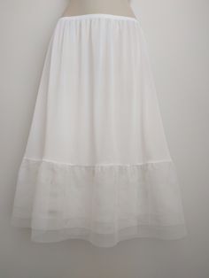 "An exquisite accessory for your wardrobe, this feminine underskirt slip worn with your skirt or dress will make you feel very special! It is made of black nylon with elastic waistband and 6 inches very soft 3 layer cobalt blue tulle ruffle trim. Also available in black. Standard length is 25\" and petite is 21\". This accessory makes a perfect gift! Hand wash in cold water. Available in sizes: XS-0-2, Waist: 24 1/2\", Hip: 35\" S-4-6, Waist: 25 1/2\"-26 1/2\", Hip: 36-37\" M-8-10, Waist: 27 1/2 White Flowy Ruffled Petticoat, White Ruffled Skirt Petticoat, White Ruffled Lace Petticoat, Black Ruffled Petticoat, Dress Extender Slip, Slip Extender, Skirt Extender, Tulle Underskirt, Ivory Skirt