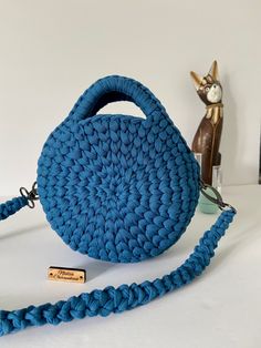 a blue crocheted purse sitting on top of a table