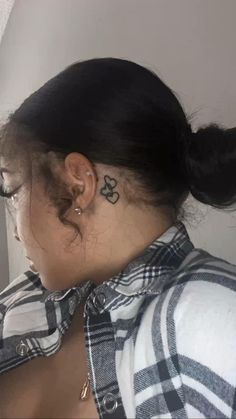 a woman with a flower tattoo on her left side of her neck and behind her ear