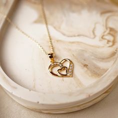 Treat your mom to a heartfelt gift with our exquisite Heart Pendant Necklace, covered in 18K gold. This elegant piece is designed to express your love and appreciation for the most special woman in your life. The delicate heart-shaped pendant exudes timeless charm, making it a perfect symbol of your affection. Crafted with meticulous attention to detail, this necklace is made from high-quality materials to ensure its lasting beauty. The gold plating adds a touch of luxury, making it a stunning accessory for any occasion. Whether it's for Mother's Day, her birthday, or just to show how much she means to you, this necklace is sure to bring a smile to her face. The adjustable chain allows for a comfortable fit, and the secure clasp ensures it stays in place throughout the day. Present her wit Yellow Gold Heart Necklace For Anniversary And Mother's Day, Yellow Gold Heart Necklace For Mother's Day Anniversary, Yellow Gold Heart Necklace With Birthstone For Anniversary, Yellow Gold Heart Necklace For Anniversary On Mother's Day, Gold Heart Necklace With Birthstone For Anniversary, Gold Heart Necklace With Birthstone For Gift, Gold Heart Necklace With Hallmark For Anniversary, Gold Plated Necklaces For Anniversary On Mother's Day, Gold Heart Necklace As A Fine Jewelry Gift