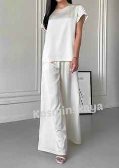 White satin two piece pantsuit is stylish and comfortable!  Our relaxed fit set consists of a short sleeve shirt and wide leg pant, which are suitable for a variety of occasions for an elegant casual look for every day, wedding guests, parties, birthdays, bachelorette parties and more.  Complete the outfit with your favorite accessories and appropriate high-heeled shoes or comfortable sandals and you're all set.     DETAILS - white  - satin  - loose fit - crew neck - short sleeve - wide leg   SIZES   This suit is available in 4 sizes S, M,  L and XL  T-shirt back length 24"/ 61 cm Shoulder 4.7"/ 12 cm  Pants inseam 29"/ 74 cm Outseam 41.33"/ 105 cm    S BUST 34 inches / 88 cm WAIST 26 inches /67 cm HIPS 37 inches / 96 cm M  BUST 36 inches / 92 cm WAIST 28 inches / 71 cm HIPS 39 inches / 10 Elegant Workwear Pantsuit With Matching Set, White Straight Pants Wedding Set, Elegant Matching Pant Set For Workwear, Elegant Two-piece Wide Leg Pantsuit, Formal Summer Wide Leg Sets, Formal Summer Wide-leg Sets, White Two-piece Set With Short Sleeves, Elegant Wide Leg Sets, White Chic Two-piece Pant Set