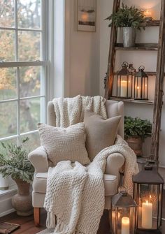 a living room filled with furniture and lots of candles in front of a large window