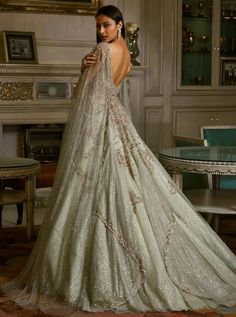 the back of a woman's wedding dress in front of a table with chairs