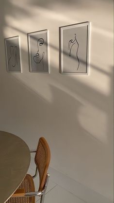 three framed pictures hang on the wall above a table