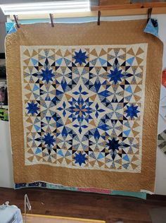 a blue and white quilt hanging on a wall