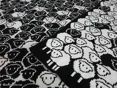 a black and white knitted blanket with skulls on it