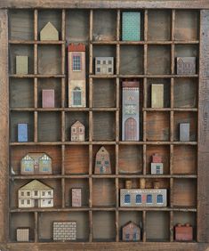 an old wooden shelf filled with miniature buildings