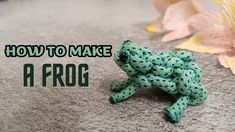 a frog toy sitting on the ground next to flowers and text how to make a frog