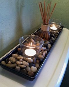 candles and rocks in a tray on top of a toilet