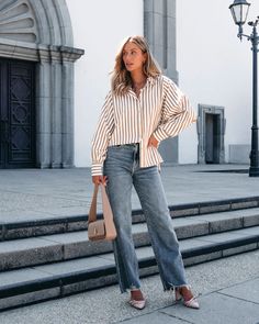 The Muse By Magnolia Camel Striped Button Down Shirt is perfect for work! This classic, collared top features long sleeves with buttoned cuffs, a button down front, and a high low hem with side slits. Perfect for any occasion, this shirt adds a touch of elegance to any outfit. Style with your favorite trousers, strappy heels, and a matching crossbody bag for an elevated workwear look! Fall Business Casual Button-up Blouse, Fall Business Casual Blouse With Spread Collar, Fall Business Casual Blouse With Placket, Business Casual Fall Blouse With Placket, Classic Fall Blouse For Day Out, Fall Day Out Shirt With Spread Collar, Classic Fall Shirt For Day Out, Collared Shirt For Day Out In Fall, Fall Shirt With Collared Neckline For A Day Out