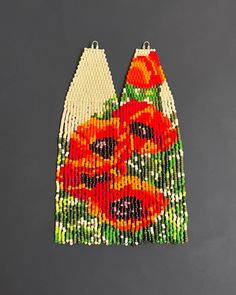 a pair of beaded earrings with an orange flower on the front and back side