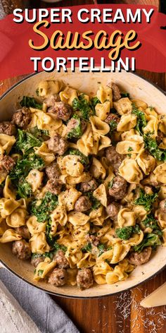 a skillet filled with sausage tortellini and spinach on top of a wooden table