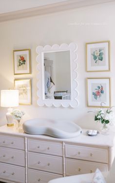 a white dresser topped with lots of drawers and a mirror over it's top