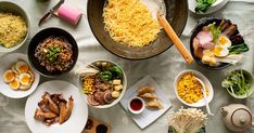 a table topped with lots of different types of food on plates and serving utensils